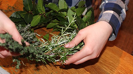 Making a fresh culinary herb wreath.