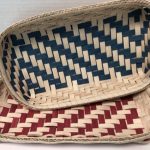 Two woven bread trays one with a blue design, and one with a red design